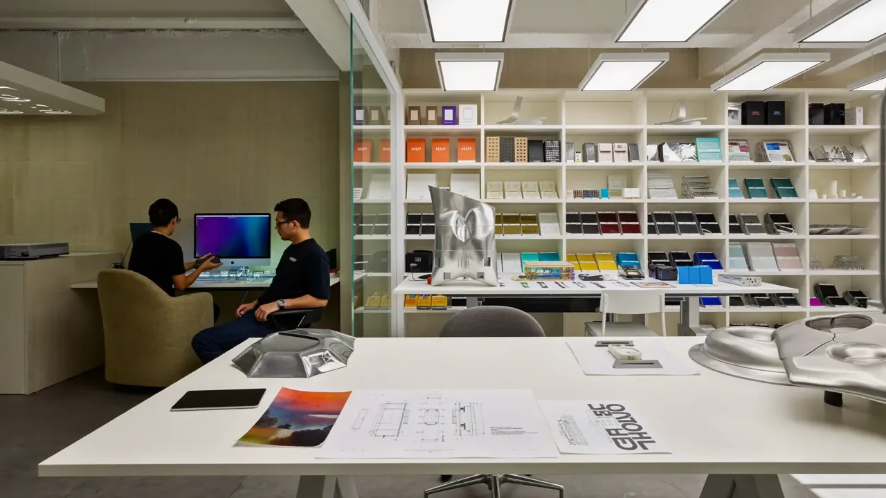 A studio workstation beside shelves of material samples